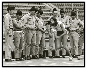 Debbie Van Kiekebelt en course devant des soldats