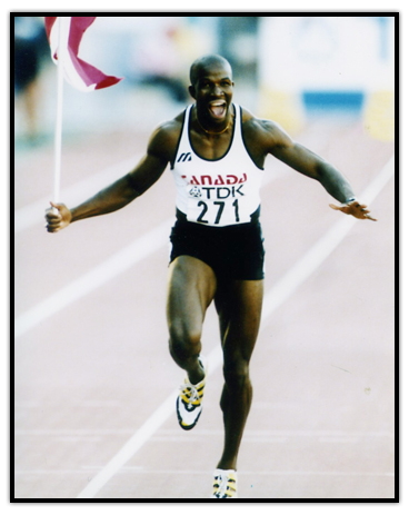 Donovan Bailey célèbre sur la piste avec le drapeau canadien