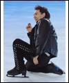 Elvis Stojko performs with a knee on the ice