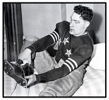 Hugh Stirling sits down to take off a shoe